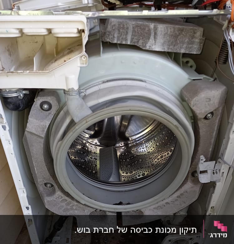 פנים מכונת כביסה פתוחה עם תוף מתכת